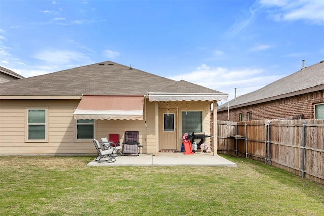 back of house featuring a yard, a patio area, a fenced backyard, and roof with shingles