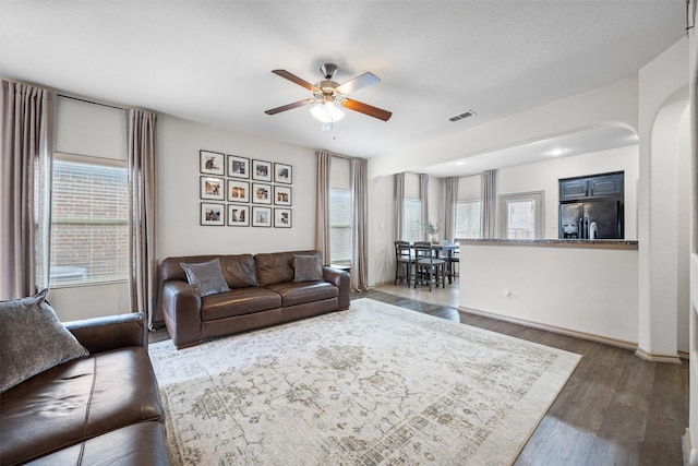 living room with visible vents, a healthy amount of sunlight, ceiling fan, and wood finished floors