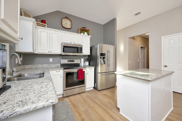 kitchen featuring visible vents, light wood-style flooring, a sink, appliances with stainless steel finishes, and white cabinets