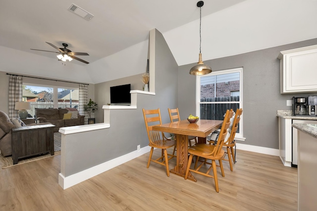 dining room with light wood finished floors, visible vents, baseboards, and lofted ceiling