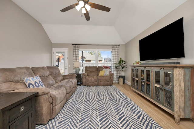 living room featuring a ceiling fan, lofted ceiling, and light wood-style floors