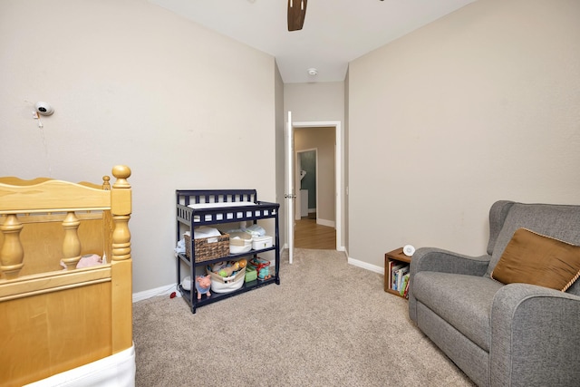 living area with carpet flooring, a ceiling fan, and baseboards