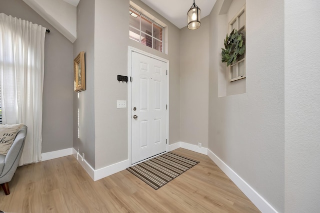 entrance foyer featuring plenty of natural light, baseboards, and light wood-type flooring