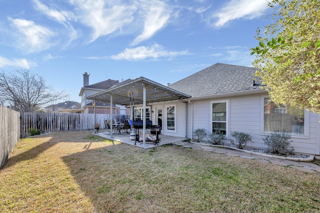 back of property featuring a patio area, a lawn, a fenced backyard, and a shingled roof