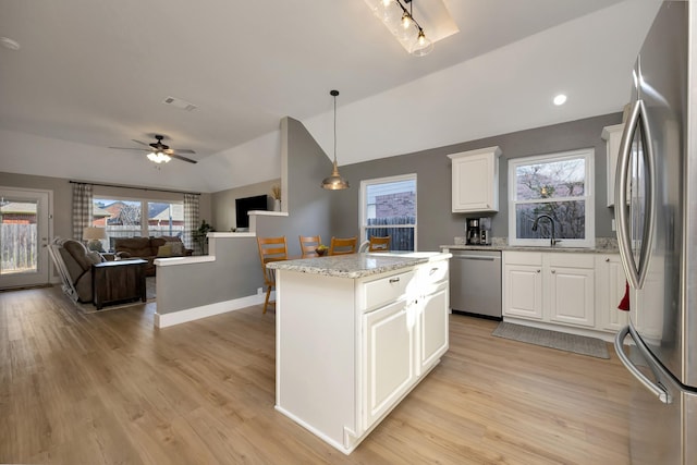 kitchen with visible vents, a healthy amount of sunlight, a center island, light wood-type flooring, and appliances with stainless steel finishes