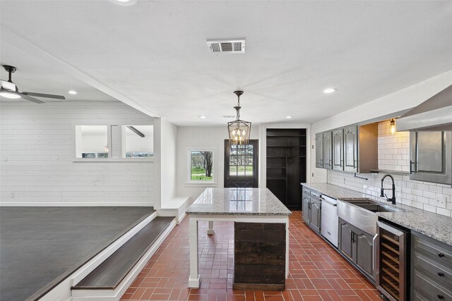 kitchen with backsplash, gray cabinetry, beverage cooler, dishwasher, and a sink