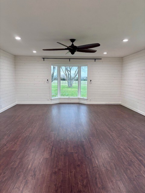 empty room with recessed lighting, baseboards, dark wood finished floors, and a ceiling fan