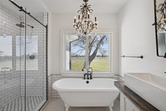 full bath with a soaking tub, a stall shower, tile patterned floors, and a chandelier