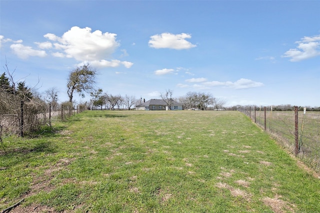 view of yard with a rural view and fence