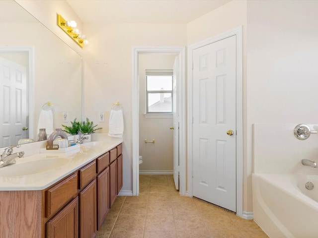 full bathroom with tile patterned floors, toilet, a washtub, a sink, and double vanity