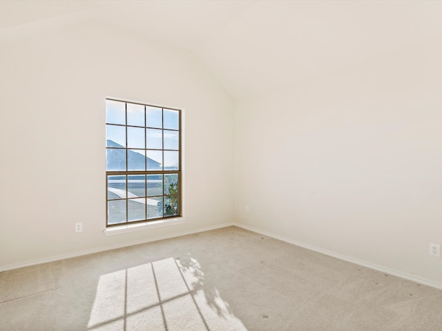 unfurnished room with baseboards, lofted ceiling, and carpet