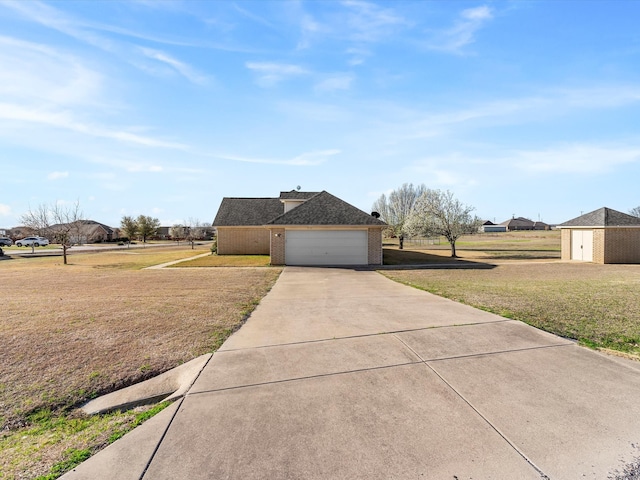 view of side of property with a yard, roof with shingles, concrete driveway, a garage, and brick siding