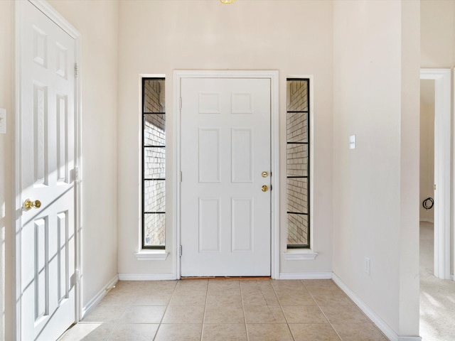 foyer entrance featuring light tile patterned floors and baseboards