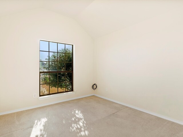 carpeted empty room with lofted ceiling and baseboards