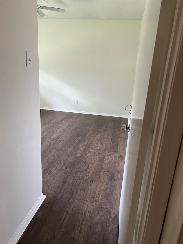 unfurnished room with dark wood-style floors, baseboards, and ceiling fan