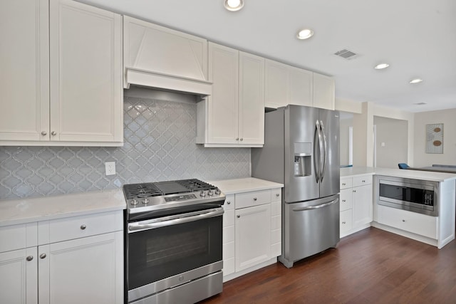 kitchen featuring dark wood-style floors, a peninsula, recessed lighting, stainless steel appliances, and tasteful backsplash