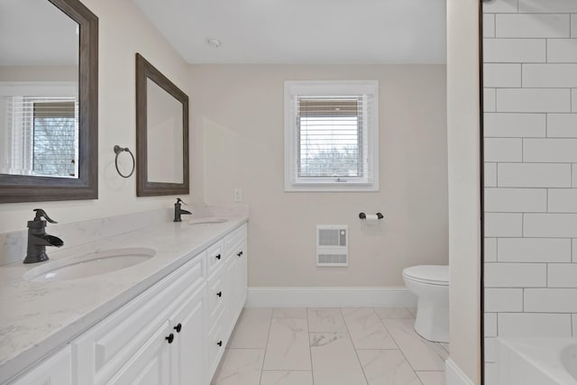 bathroom with a sink, baseboards, heating unit, and marble finish floor