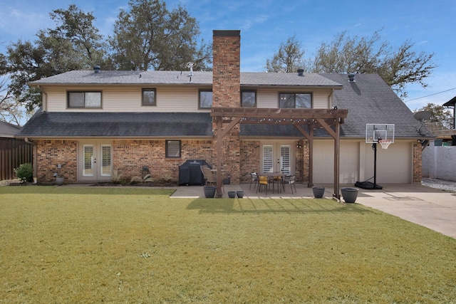 back of property with french doors, a pergola, driveway, and a yard