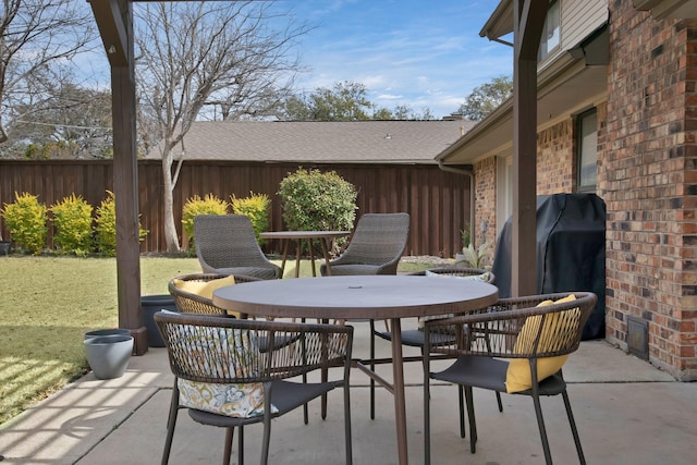 view of patio / terrace with grilling area, outdoor dining space, and fence