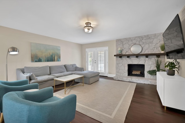 living area with dark wood-style floors, a fireplace, and french doors