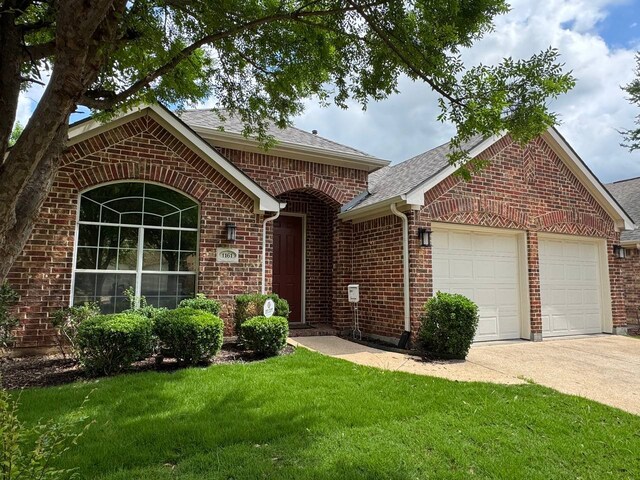 1161 Mission Ln, Lantana, TX 76226 - ranch-style house featuring an attached garage, brick siding, concrete driveway, and a front yard