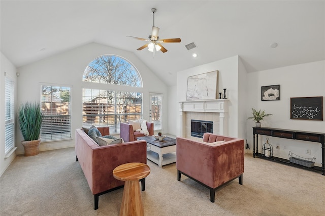 living room with a ceiling fan, visible vents, high vaulted ceiling, a fireplace, and light colored carpet