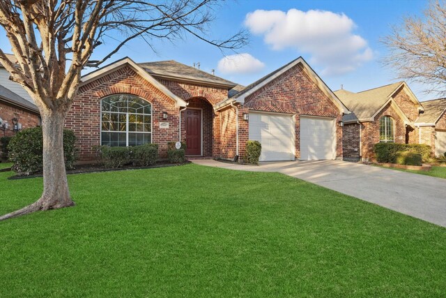 1161 Mission Ln, Lantana, TX 76226 - view of front facade with brick siding, a garage, a front yard, and concrete driveway