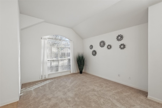 unfurnished room with lofted ceiling and carpet flooring