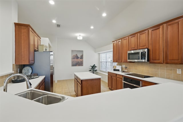 kitchen with decorative backsplash, lofted ceiling, appliances with stainless steel finishes, and a sink