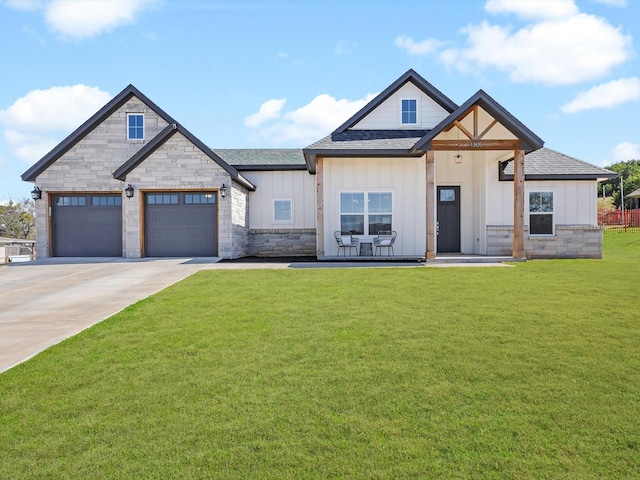 view of front facade featuring a front lawn, stone siding, board and batten siding, concrete driveway, and a shingled roof