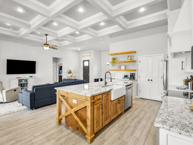 kitchen with a sink, open shelves, beam ceiling, and stainless steel appliances