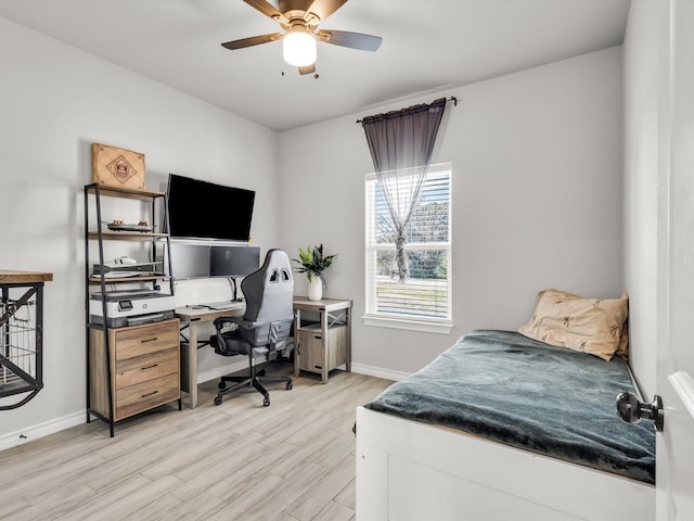 bedroom featuring light wood-style flooring, a ceiling fan, and baseboards