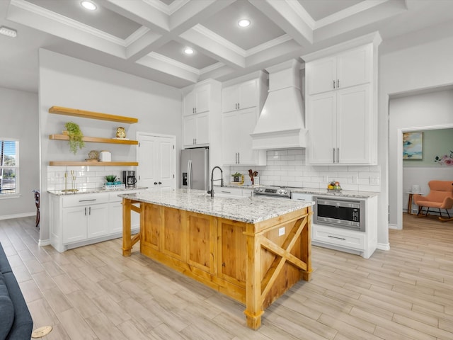 kitchen with open shelves, beam ceiling, appliances with stainless steel finishes, and custom range hood