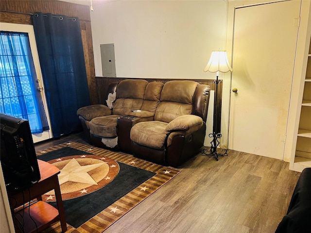 living area featuring electric panel and wood finished floors