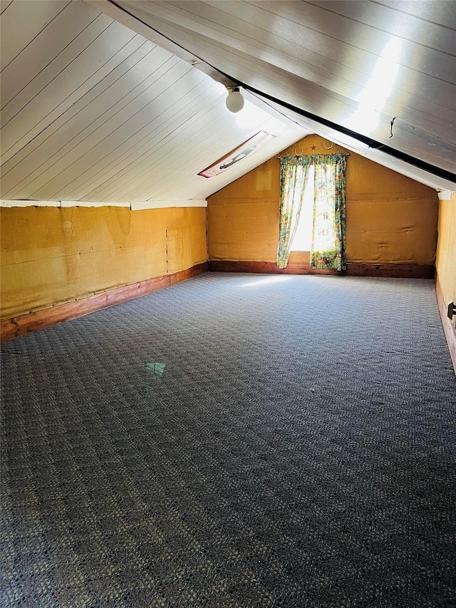 bonus room with lofted ceiling, wooden walls, and carpet flooring