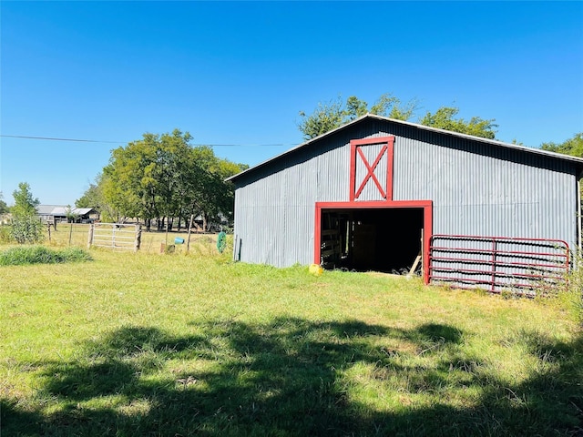 view of pole building featuring a lawn and fence