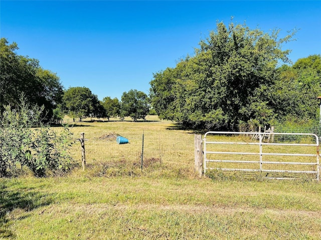 view of yard featuring a rural view and fence