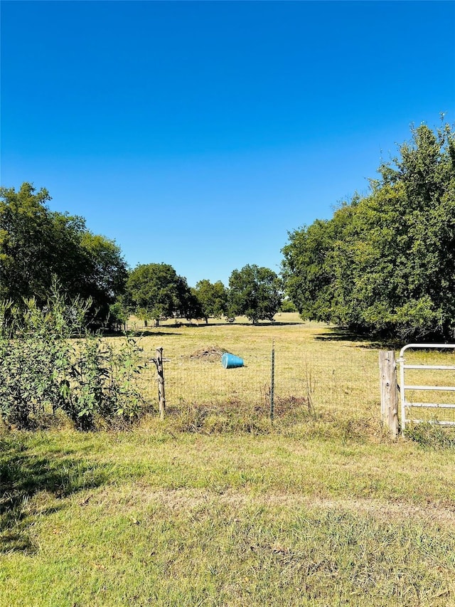 view of yard featuring a rural view and fence