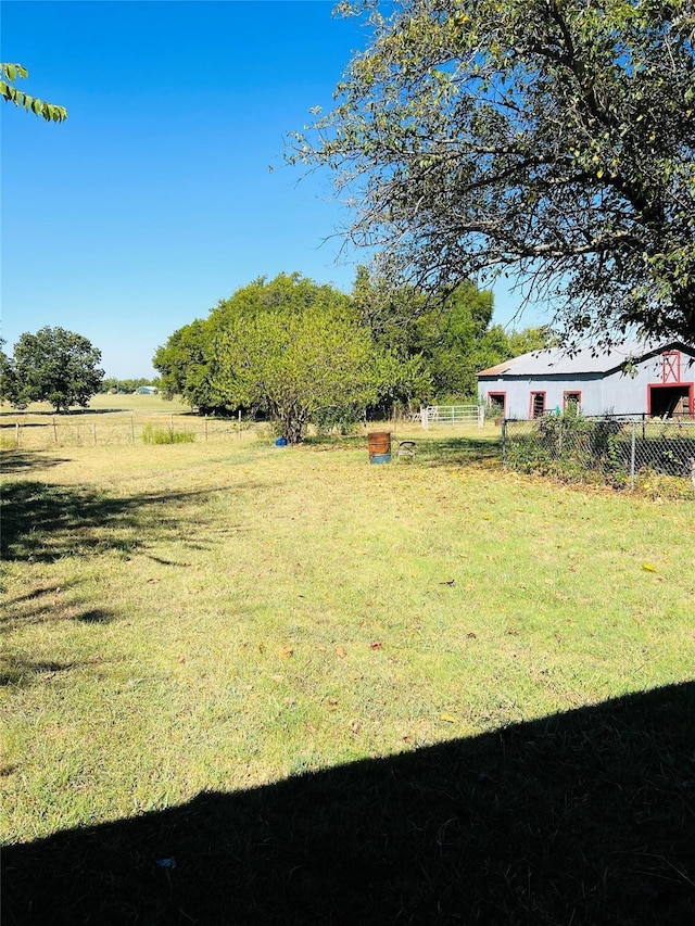 view of yard with a rural view and fence