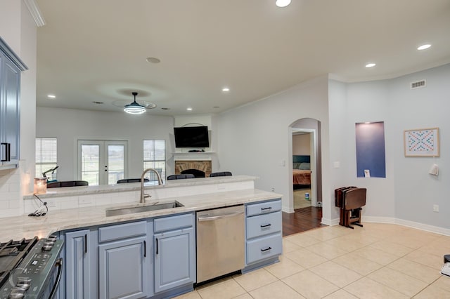 kitchen featuring visible vents, a fireplace, a sink, black range with gas stovetop, and dishwasher