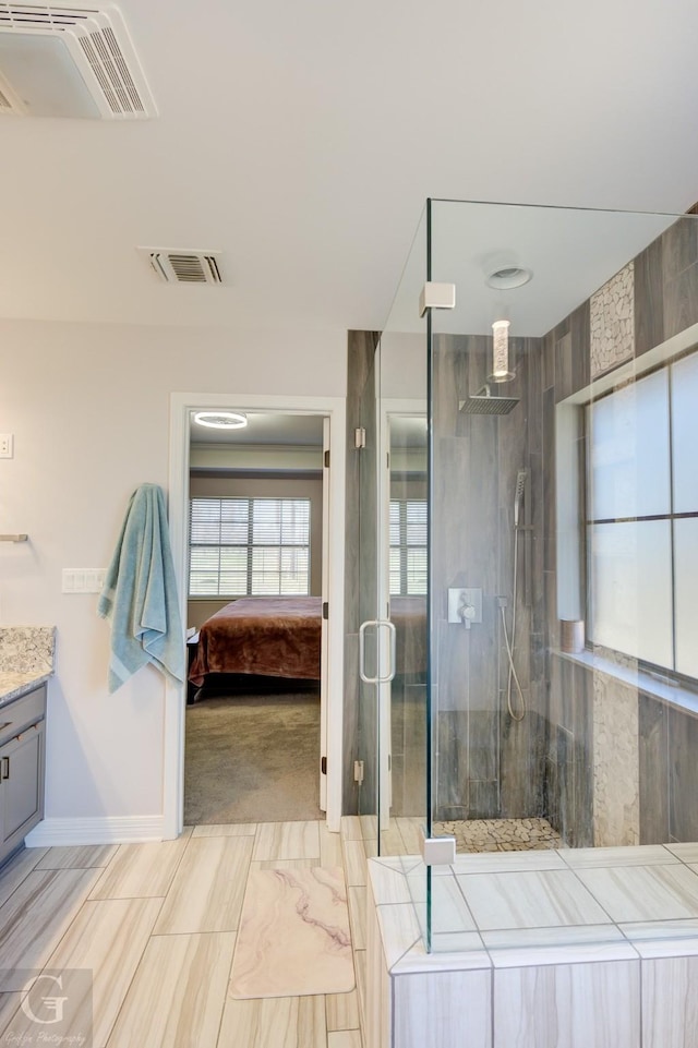 ensuite bathroom with vanity, visible vents, ensuite bathroom, and a stall shower