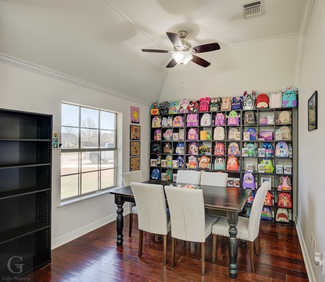 dining room with visible vents, ornamental molding, hardwood / wood-style floors, baseboards, and vaulted ceiling