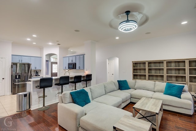 living area with arched walkways, recessed lighting, a ceiling fan, and wood finished floors