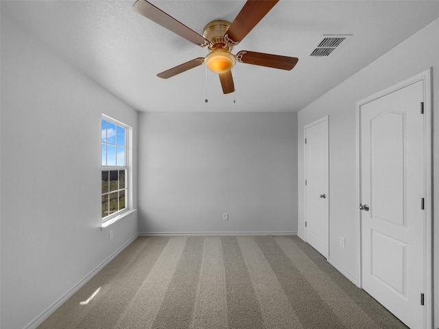 unfurnished bedroom featuring visible vents, carpet flooring, a ceiling fan, and baseboards