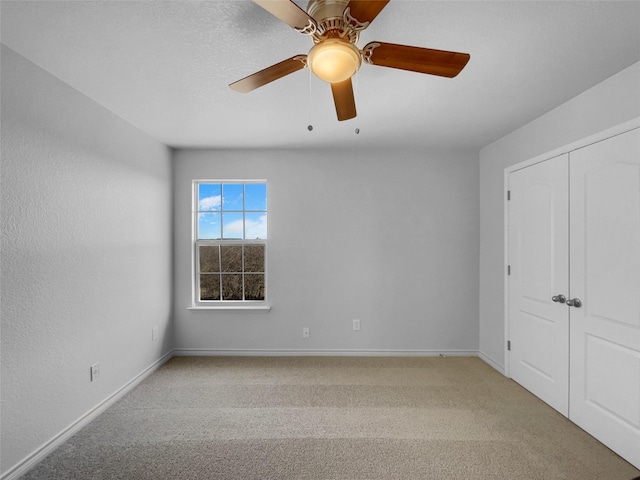 unfurnished room with light carpet, ceiling fan, and baseboards