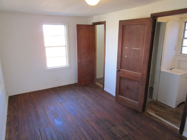 unfurnished bedroom with baseboards and dark wood-style flooring