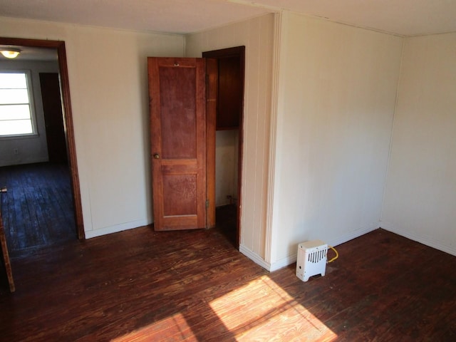 empty room with dark wood finished floors and baseboards