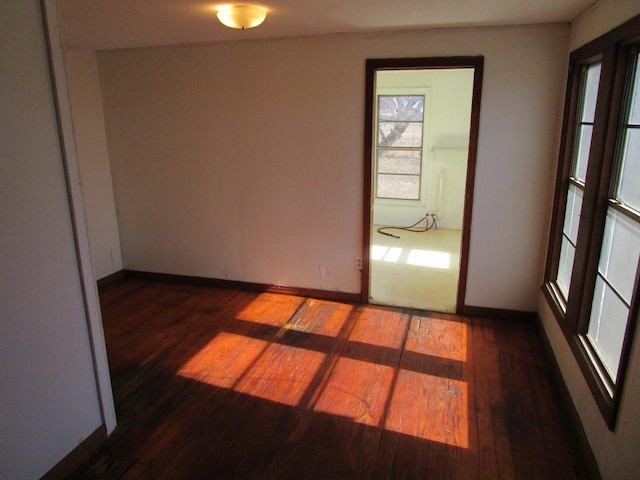 spare room featuring wood finished floors and baseboards