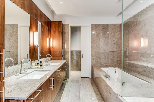 full bathroom featuring tile walls, a bath, double vanity, and a sink