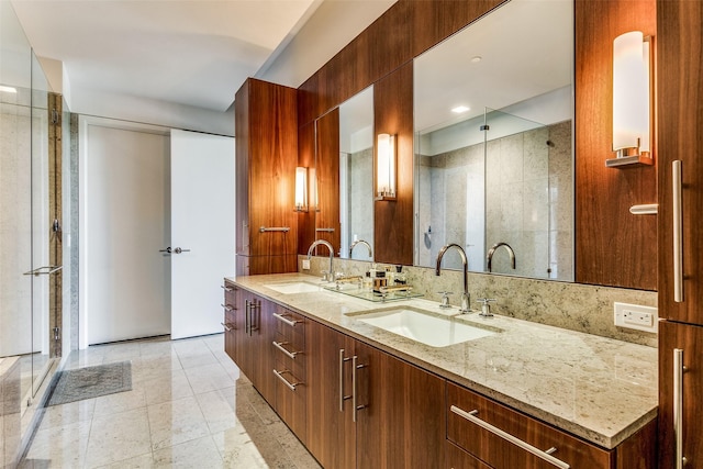 bathroom with a shower stall, double vanity, backsplash, and a sink